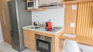 a small kitchen with a sink and a refrigerator at Studio Metrô Tucuruvi in São Paulo
