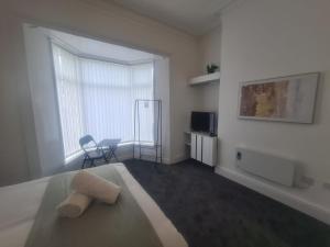 a bedroom with a bed and a television and a window at Modern Studios in Sunderland