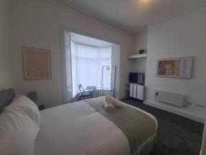 a bedroom with a bed with a stuffed animal on it at Modern Studios in Sunderland