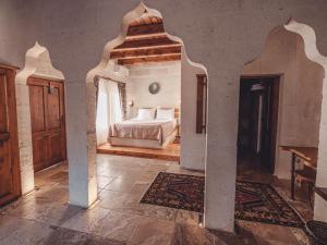 une chambre avec un lit dans une pièce avec une arcade dans l'établissement Hanzade Cappadocia, à Gorëme