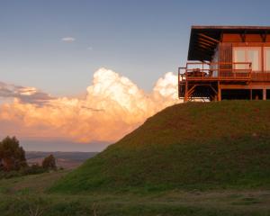 a house on top of a grassy hill at El Abrazo de las Sierras in Minas