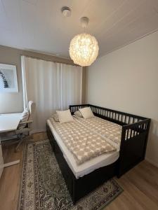 a bedroom with a bed and a chandelier at Villa Aurora Noir in Rovaniemi
