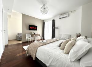 グロッセートにあるResidence Il Boschetto - Villa Con Piscinaのベッドルーム(シャンデリア付きの白い大型ベッド1台付)