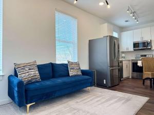a living room with a blue couch and a kitchen at New 1B1B Condo in Old Fourth Ward 542Blvd207 in Atlanta
