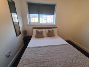 a small bedroom with a bed with a window at Stylish 3 bed close to Nissan in Sunderland