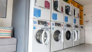 a row of washing machines in a laundry room at Studio Metrô Tucuruvi in São Paulo