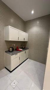 een keuken met witte kasten en een aanrechtblad bij شقة بصالة وغرفه نوم in Hafr Al Baten +8 foto's