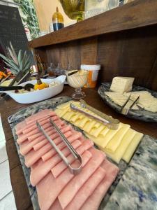 Una mesa cubierta con quesos, carnes y utensilios. en Pousada do Rock, en Arraial d'Ajuda 139 fotos más