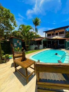 una piscina con un banco y una casa en Pousada do Rock, en Arraial d'Ajuda