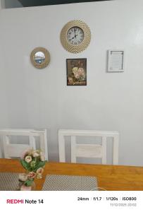 Zimmer mit einem Tisch und einer Uhr an der Wand in der Unterkunft Chic Haven Home away from home in Imus