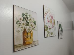 3 Bilder von Blumen in einer Vase an der Wand in der Unterkunft Chic Haven Home away from home in Imus