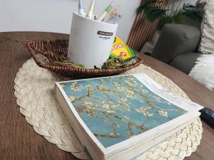 ein Buch auf einem Tisch neben einem Korb mit Stiften in der Unterkunft Chic Haven Home away from home in Imus