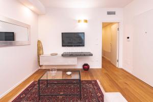 a living room with a table and a tv on a wall at VITTO Luxury Apartment in Lecce