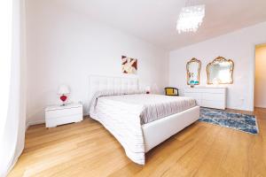 een witte slaapkamer met een bed en 2 spiegels bij VITTO Luxury Apartment in Lecce
