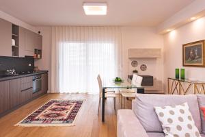 een keuken en woonkamer met een tafel en een bank bij VITTO Luxury Apartment in Lecce