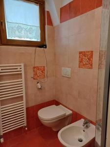 a small bathroom with a toilet and a sink at Silvia's Home in Calalzo