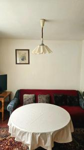 ein Wohnzimmer mit einem roten Sofa und einem weißen Tisch in der Unterkunft Stan na dan - Apartman Centar Kakanj in Kakanj