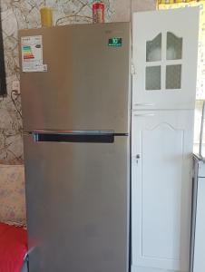 een zilverkleurige koelkast naast een witte koel-vriescombinatie bij Cabañas Sandra Bucalemu Alto in Bucalemu
