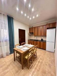 a kitchen with a wooden table and a white refrigerator at Holiday Home Kanyon in Argel