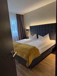 a bedroom with a large bed with a blue headboard at Vinotel Dirmstein in Behringen