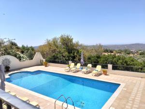 een zwembad met ligstoelen naast een zwembad bij Casa do Monte in Loulé