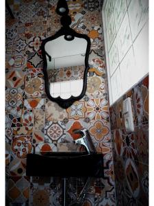 een badkamer met een spiegel op een tegelmuur bij House Kellisch 1822 in Steffeln +83 foto's