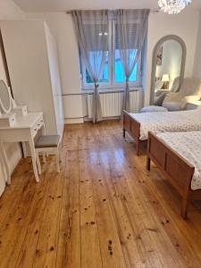a bedroom with two beds and a desk and a table at Holiday&wellness house Grofica in Daruvar