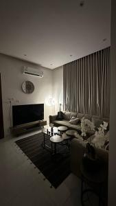 een woonkamer met een bank en een tafel bij شقة بصالة وغرفه نوم in Hafr Al Baten