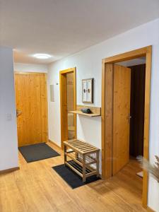 a room with wooden doors and a stool in it at BergSee Apartament Laax in Laax