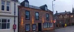ein Backsteingebäude mit Beleuchtung an einer Straße in der Unterkunft Hotel Room in Maybole for Work Travel & Leisure in Maybole