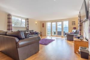 a living room with couches and a tv at Groeslon Uchaf in Caernarfon