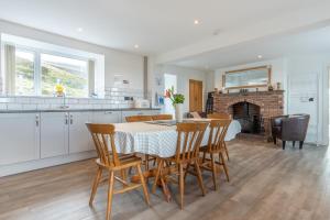 a kitchen and dining room with a table and chairs at Groeslon Uchaf in Caernarfon
