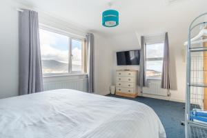 a bedroom with a bed and a large window at Groeslon Uchaf in Caernarfon