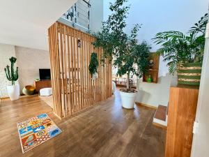 a living room with potted plants and a book on the floor at Urban Oasis - Duplex Design, Piscine privée in Perpignan
