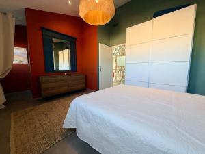 a bedroom with a white bed and a mirror at Urban Oasis - Duplex Design, Piscine privée in Perpignan +26 photos
