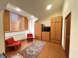 a living room with a red chair and a rug at Holiday Home Kanyon in Argel