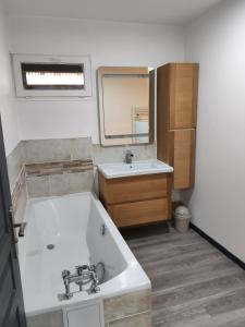 een badkamer met een ligbad en een wastafel bij L'appart' Bivillais in Biville-sur-Mer