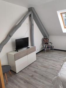 een woonkamer met een tv op zolder bij L'appart' Bivillais in Biville-sur-Mer