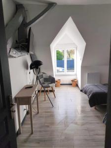 een slaapkamer met een bed, een bureau en een raam bij L'appart' Bivillais in Biville-sur-Mer +4 foto's