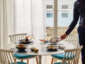 a table with plates of food and wine glasses at Sofitel Golfe d'Ajaccio Thalassa Sea & Spa in Ajaccio