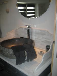 La salle de bains est pourvue d'un lavabo en pierre et d'un miroir. dans l'établissement L'Etoile Filante et Constellations, à Wimereux