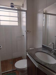 a bathroom with a sink and a toilet and a shower at Apartamento bem localizado com quintal privativo in Taubaté