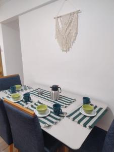 a dining room table with a tea set on it at Apartamento bem localizado com quintal privativo in Taubaté