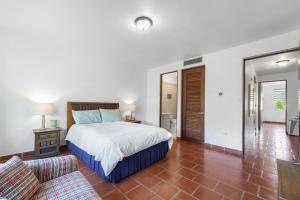 Un dormitorio con una cama grande y un sofá. en Quaint villa Beach access Elina, en Brenas
