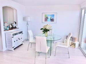 een eetkamer met een glazen tafel en witte stoelen bij Exclusive Ocean Views in Los Realejos