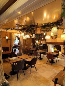 ein Restaurant mit Tischen und Stühlen in einem Raum in der Unterkunft Hôtel Saint Jacques in Thorigné-sur-Dué