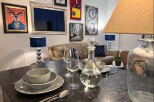 un tavolo con piatti e bicchieri da vino sopra di The Plaza, King 1 Bedroom Suite by The Hive WA1 a Warrington