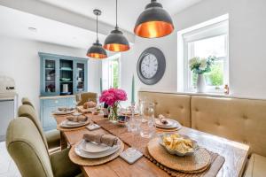 a dining room with a table with chairs and a clock at 4 Bed in Instow oc-clevv in Instow