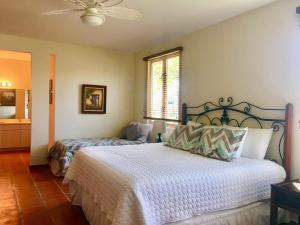 a bedroom with two beds and a ceiling fan at Giovanni Beachfront community w pools in Brenas