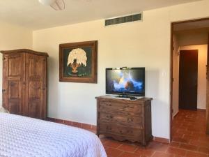 a bedroom with a bed and a tv on a dresser at Giovanni Beachfront community w pools in Brenas